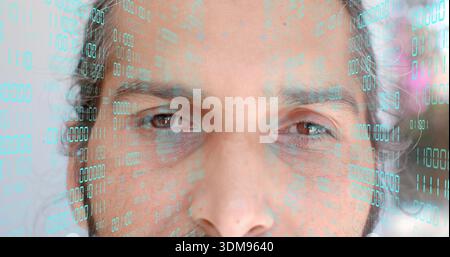 Staring mid-adult Indian man showing eyes and beard in studio close-up, with teal binary overlay Stock Photo