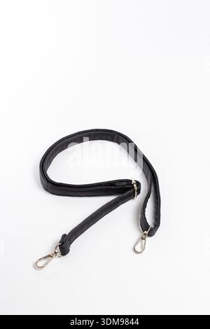 Close-up of black leather bag strap with two metal carabiners. Stock Photo