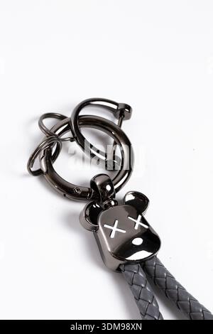 Black metallic bear keychain with braided leather strap isolated on white background Stock Photo