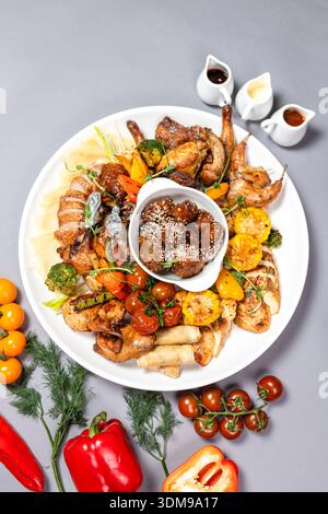 Grilled Chicken Sharing Platter with Veggies, Sesame Mushrooms and Sauces Top View Stock Photo