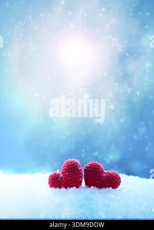 Happy valentines day background with two red hearts on white snow. Stock Photo