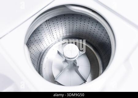 Empty washing machine drum closeup. Household laundry appliance interior and modern home cleaning equipment concept indoors. Stock Photo