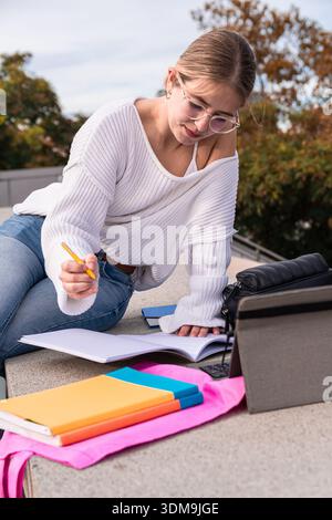 Young woman student studying outdoors on campus Stock Photo