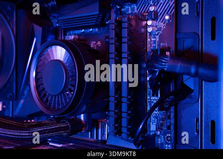 Close up of desktop computer motherboard with dual memory modules, liquid cooling tubes and internal power connections inside a modern PC case Stock Photo