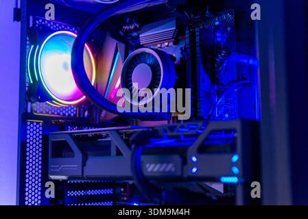Close up of gaming computer interior showing rgb cooling fan, liquid cooled processor, graphics card and motherboard inside modern pc case Stock Photo