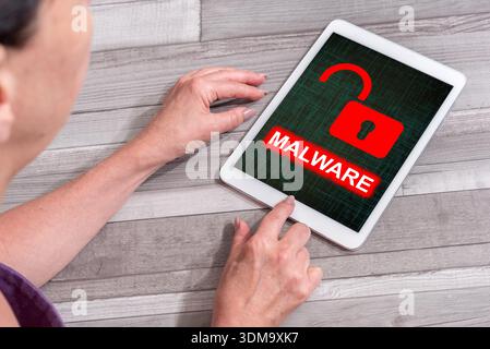 Woman using a tablet showing malware concept Stock Photo