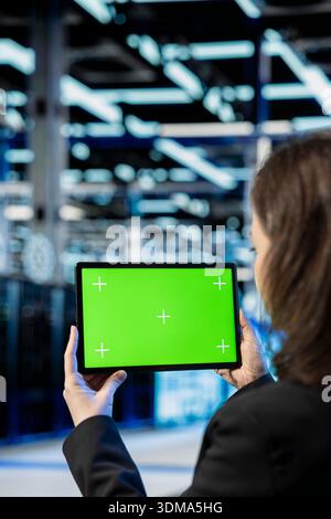 Isolated screen tablet used by data center admin to inspect infrastructure, updating network systems. Close up of employee using chroma key device to ensure stable server hub operations Stock Photo
