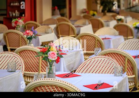 Outdoor tables waiting for customers at a street cafe in the Old Town, Vieille Ville of Nice, South of France Stock Photo