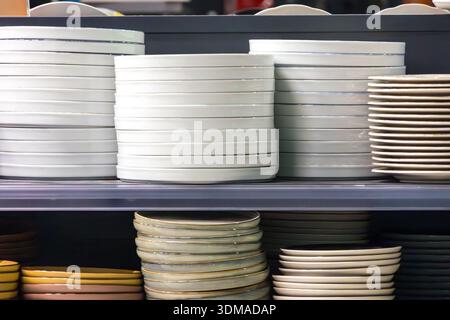 Empty ceramic plates stack inside shop interior on shelf Stock Photo