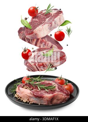 Fresh beef steaks falling on white background Stock Photo