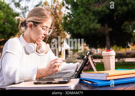 Young woman student outdoors using digital tablet for studying Stock Photo