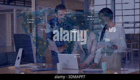 Analyzing three coworkers wearing shirt, blazer, reviewing world map on laptop and tablet at office Stock Photo