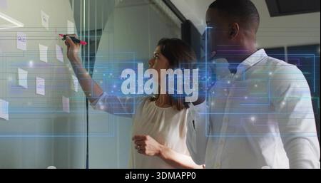 Writing team in business attire on glass wall in office, with pink marker, sticky notes, holograms Stock Photo