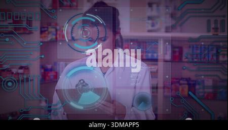 Holding pharmacist in white lab coat, checking tablet in pharmacy at meds shelves, with holograms Stock Photo