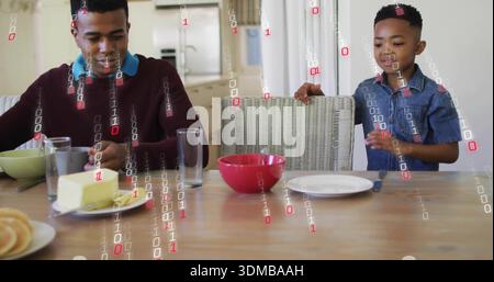 Spreading butter, man in maroon sweater handling knife at wood dining table, with binary overlay Stock Photo