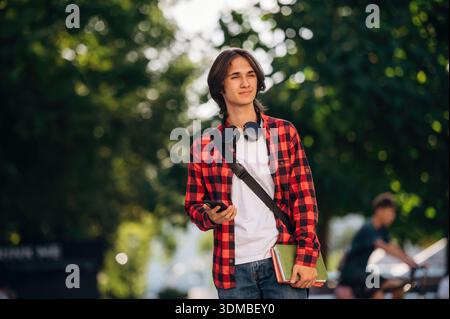 Feeling good, walking. Young student is outdoors at daytime. Stock Photo