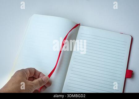 Open lined notebook with red bookmark. Isolated on white surface, top view. Space for text. Stock Photo