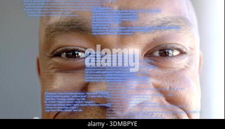 Showing mid-adult man's face filling frame at studio, with blue code projection overlay Stock Photo