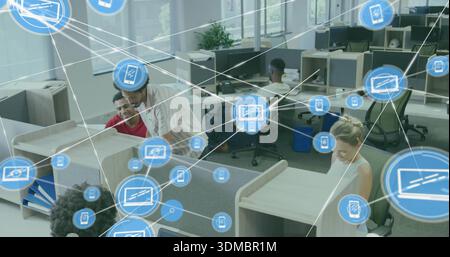 Working staff in casual dress collaborating in open-plan office cubicles with blue network overlay Stock Photo