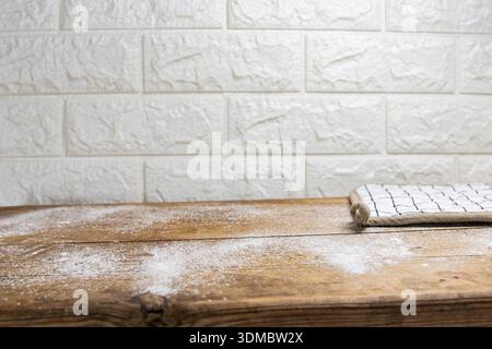 Wooden table surface with scattered flour and textile napkin kitchen background Stock Photo