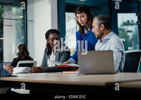Business colleagues collaborating on project documentation in office Stock Photo