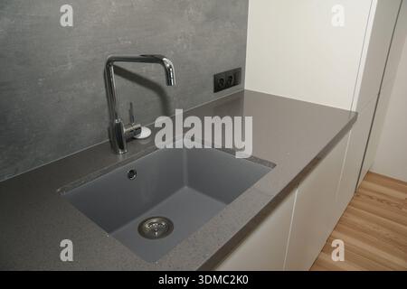 Kitchen faucet on a stylish ceramic sink Stock Photo
