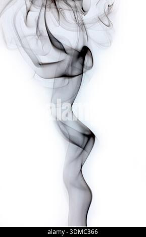 Abstract black smoke swirls rising on white background Stock Photo