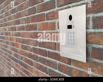 Modern Video Intercom Mounted on Brick Wall Stock Photo