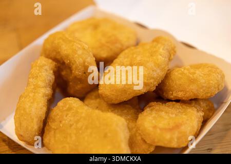 Top view of delicious deep-fried golden chicken pieces presented in a casual disposable container, perfect for a quick meal or a satisfying appetizer Stock Photo