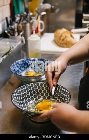 Chef beating eggs in a bowl for cooking preparation Stock Photo