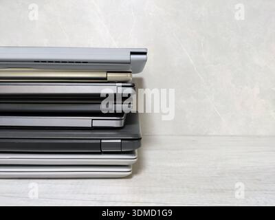 stack of laptops on a gray background, on the table, laptop computer, tablet, business, work, remote work, freelance. Stock Photo