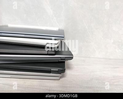 stack of pile of laptops on a gray background. many laptop computers, communications, internet, technology, equipment, tablet, netbook Stock Photo