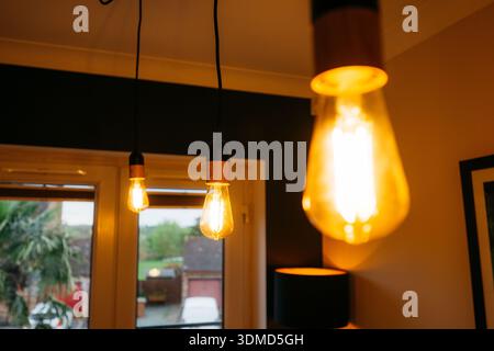 The room is lit by three light bulbs, two of which are yellow and one is white. The yellow bulbs are hanging from the ceiling, while the white bulb is Stock Photo