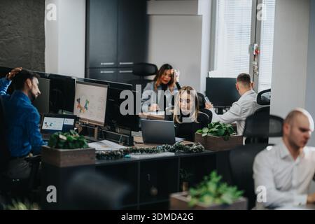Busy office scene with business employees working at desks and laptops in a modern workspace Stock Photo