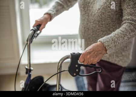 Elderly woman using a walker at home, close-up Stock Photo
