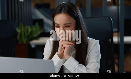 Happy pensive Caucasian business woman looking at laptop thinking working in office businesswoman cheerful think look in computer screen monitor work Stock Photo