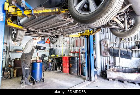 Samara, Russia - April 21, 2025: Car at the auto repair service. SUV car lifted in Service center for maintenance. Service vehicle care and repair job Stock Photo