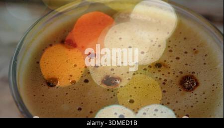 Showing cup of coffee revealing thick crema, bubbles and rim on cafe table, warm bokeh Stock Photo