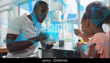 Sharing meal, man, child at kitchen counter holding bowls in polo pink top, window blue overlays Stock Photo