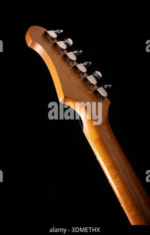 Close-up of Modern Electric Guitar Headstock with Chrome Tuning Pegs on Black Background Stock Photo