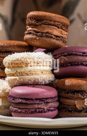 Assorted macarons stacked on decorative plate Stock Photo