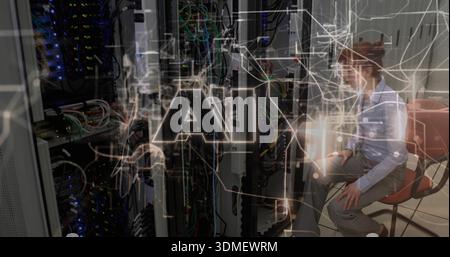 Working tech in blue-top gray-pants in server-room checking racks, tablet, AI overlay, copy space Stock Photo