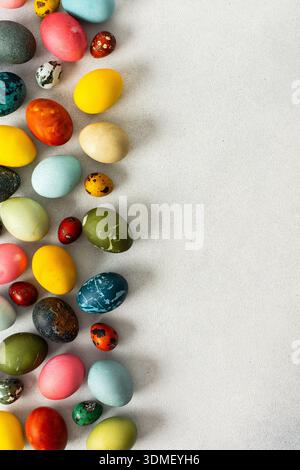 A collection of Easter eggs in bright colors and patterns is displayed on a light surface, capturing the festive spirit of Easter celebrations and spr Stock Photo
