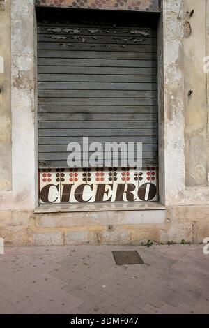 Italy, Sicily, Modica, old closed down shop with lowered blinds Stock Photo