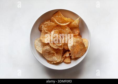 Potato chips in a white bowl Stock Photo