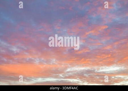 Colorful pastel clouds glowing in the sky at sunset, forming an atmospheric natural background Stock Photo