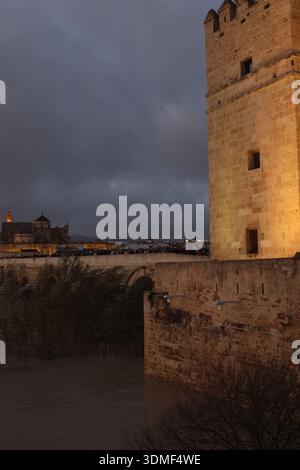 CloseUp Tower Wall At Night, Textured Stone Illuminated By Amber Floodlights, Distant City Silhouette Stock Photo