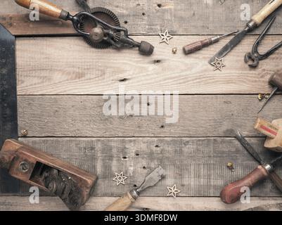 Vintage carpenter tools as a frame on a rustic wooden workbench with space for text, workshop concept Stock Photo