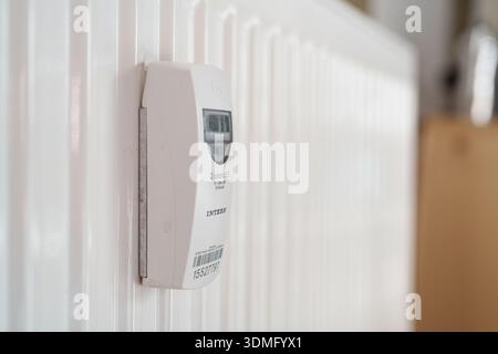 INTERN Q caloric 5.5 electronic heat cost allocator mounted on a white radiator panel Stock Photo