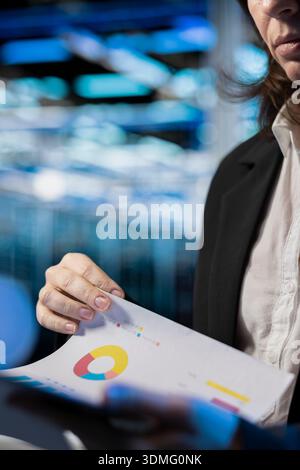 Storage rackmounts inspection, report files and specialist in server farm reading benchmarks, close up. Checkup, documentation and system administrator in data center analyzing machines parts papers Stock Photo